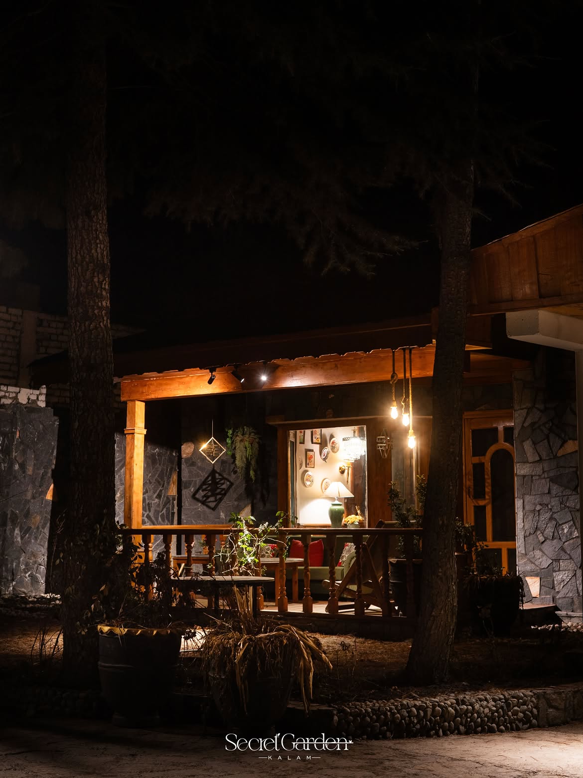 Warm wooden cottage lit up at night under pine trees