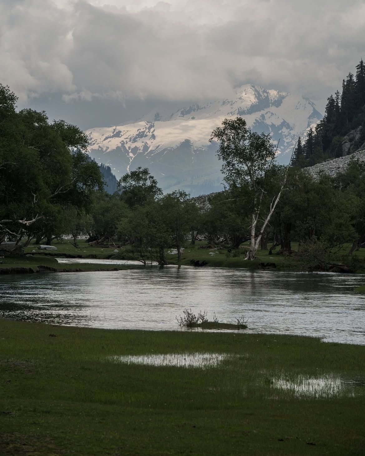 Clear reflection of snowy mountain peak in tranquil lake water